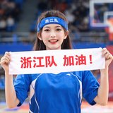 一位年轻女性篮球迷，头戴浙江队发带，手拿应援手幅